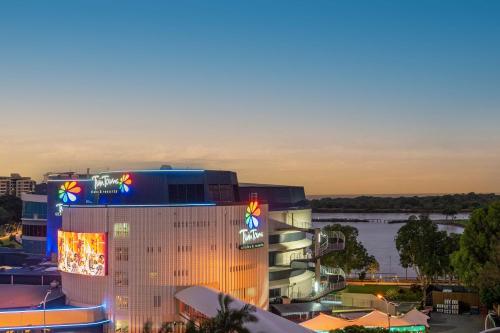 a large building with lights on it next to a river at The Sebel Twin Towns in Gold Coast