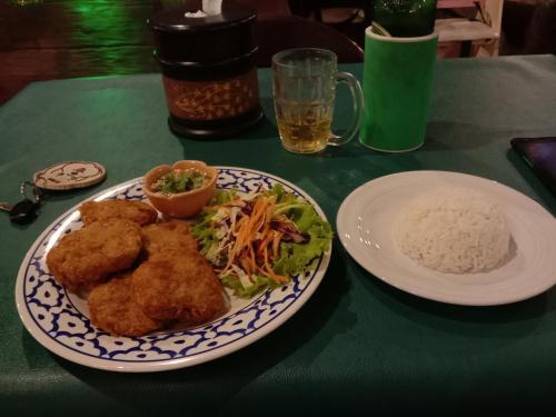 a plate of food with chicken and rice on a table at Happy Lagoon Bungalow in Khao Lak