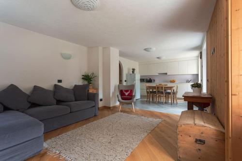 uma sala de estar com um sofá e uma cozinha em NUOVISSIMO appartamento a due passi da Bormio! em Valfurva