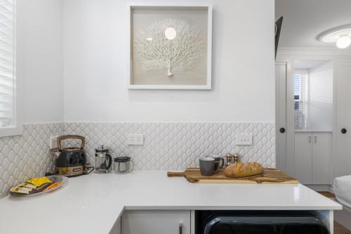 a kitchen with a white counter top with a picture on the wall at Sea Pine Studio in Sawtell