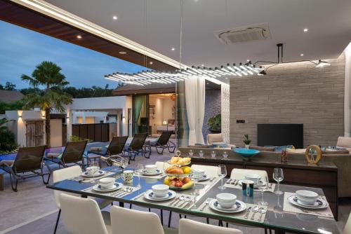 a dining room with a table and chairs in a house at Inspire Villas Phuket in Rawai Beach