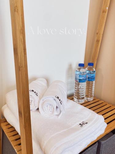a stack of towels and water bottles on a shelf at Yudao 695 in Sanxing