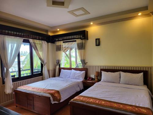 1 dormitorio con 2 camas y ventana en Rang Garden Bungalow, en Mui Ne