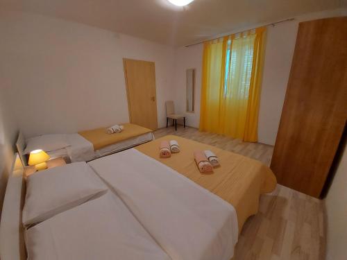 a bedroom with two beds and two slippers at Apartments Marija 2 in Draga Bašćanska