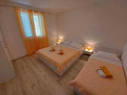 1 dormitorio con 2 camas y ventana en Apartments Marija en Draga Bašćanska