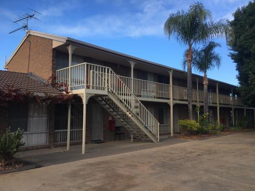 a building with a staircase and a palm tree at Darling Junction Motor Inn in Wentworth