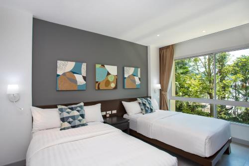 A bed or beds in a room at Happy Apartment on Karon Beach