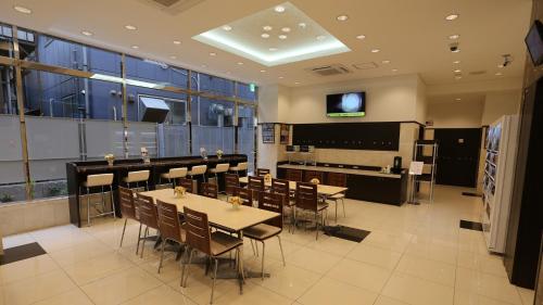 un restaurant avec des tables et des chaises et une grande fenêtre dans l'établissement Toyoko Inn Tokyo Hachioji-eki Kita-guchi, à Hachioji