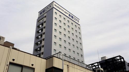 a tall white building with a sign on it at Toyoko Inn Tokyo Hachioji-eki Kita-guchi in Hachioji