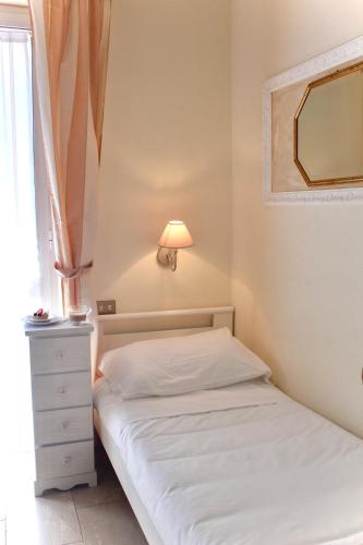 a bedroom with a bed and a lamp and a window at Hotel Tahiti in Viareggio