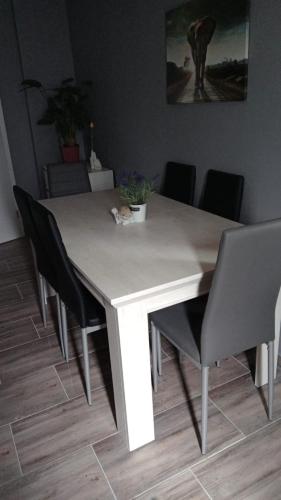 a dining table with black chairs and a white table with at Flensburg City - 24h in Flensburg