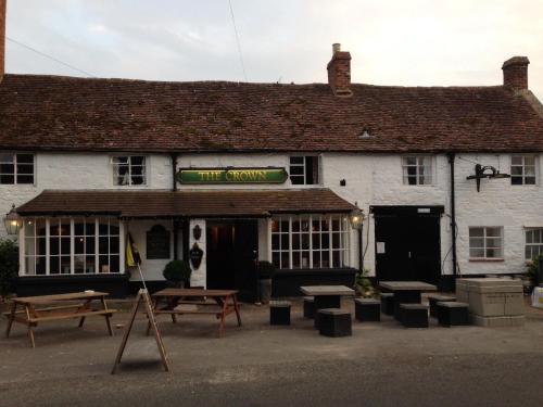 a building with benches and tables outside of it at The Crown Inn, Kemerton in Tewkesbury