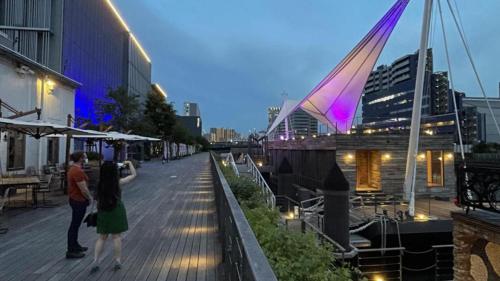 a group of people walking down a boardwalk at night at Toyoko Inn Tokyo Shinagawa Konan-guchi Tennozu Isle in Tokyo