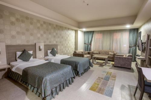 Habitación de hotel con 2 camas y sofá en Sen Otel, en Sakarya