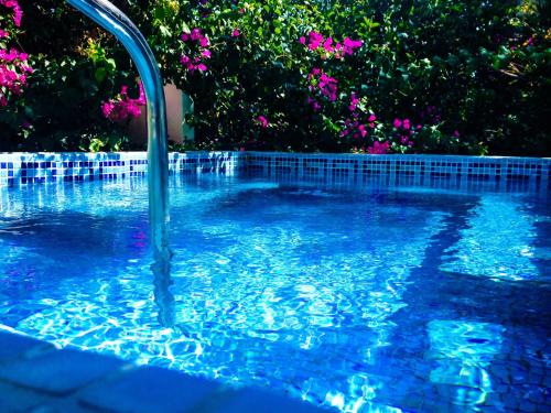 a swimming pool with a water fountain in it at Zephyros Hotel in Kamari
