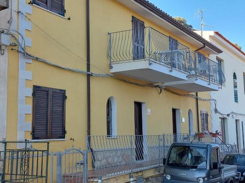 um carro estacionado em frente a um edifício amarelo em Casa Vacanze "Il Bugno" em Posada