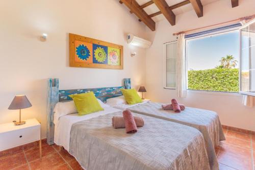 two beds in a room with a window at Racó Blau in Cap d'en Font