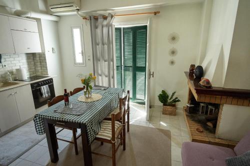 kuchnia ze stołem i krzesłami w pokoju w obiekcie Μονοκατοικία στο κέντρο με τζάκι w mieście Patras