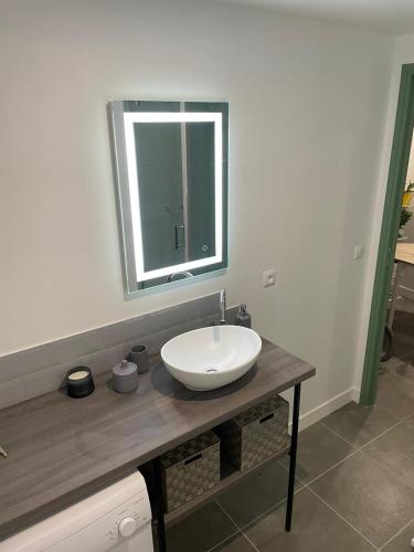 bagno con lavandino bianco e specchio di Logement entier : Studio neuf avec jardin a Vallauris