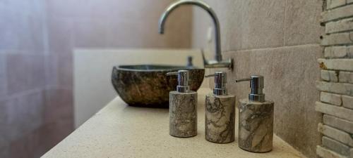 three bottles sitting on a counter next to a sink at Soraya Yoga Wellness Center in Gili Trawangan