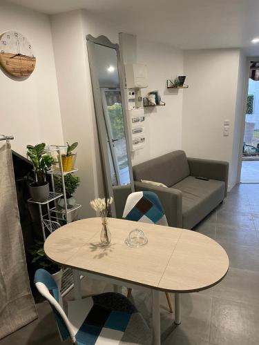 un soggiorno con tavolo e divano di Logement entier : Studio neuf avec jardin a Vallauris