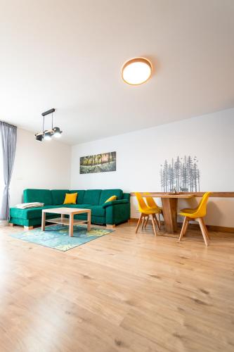 a living room with a green couch and a table at Apartmán 110 Vila Zuberec in Zuberec