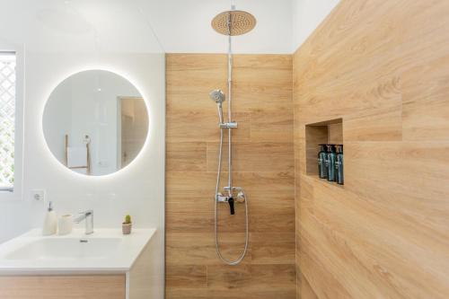 ein Bad mit einer Dusche, einem Waschbecken und einem Spiegel in der Unterkunft Villa Juanes in Ciutadella