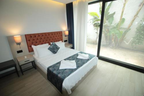 a hotel room with a bed and a large window at A'la Grand Residence in Bodrum City