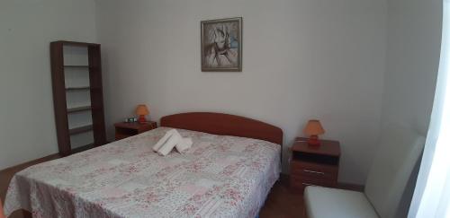 a bedroom with a bed and two tables and a picture at Apartman Oliver in Novigrad Istria