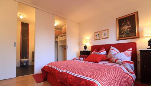 una camera con letto rosso e cuscini rossi e bianchi di Enzian 14 - Schmuckstück von Bad Kleinkirchheim a Bad Kleinkirchheim
