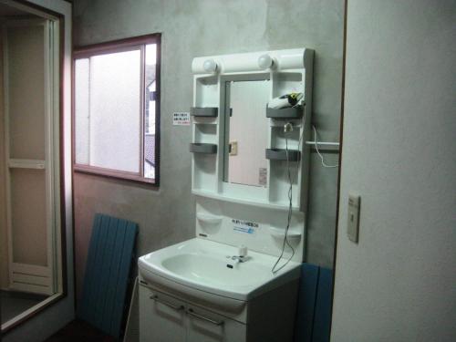 a bathroom with a sink and a mirror at Yukaina Nakamatachi in Yakushima