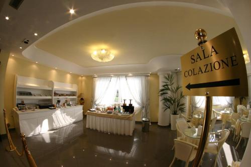 a salon with a table and chairs in a room at Hotel Luxor in Casoria
