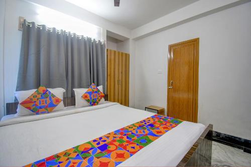 a bedroom with a bed with a colorful blanket on it at FabExpress Amar Raj Villa in Kolkata