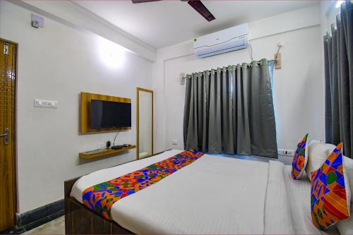 a bedroom with a bed and a television in it at FabExpress Amar Raj Villa - Nr Eco Park in Kolkata