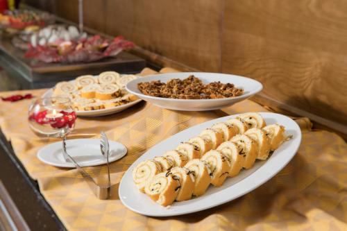 ein Buffet mit Tellern voller Essen auf einem Tisch in der Unterkunft Galina Hotel & Spa in Nha Trang