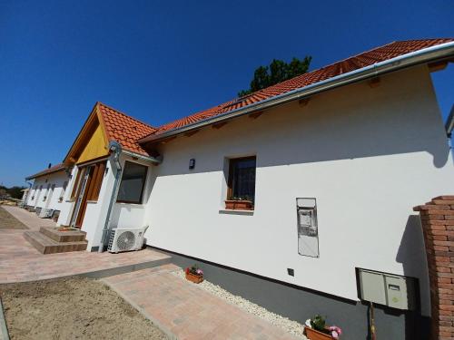 une maison blanche avec un toit rouge dans l'établissement Fazekas Vendégház, à Balatonkeresztúr