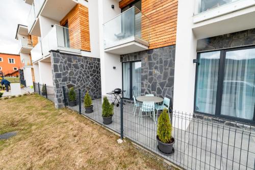 a house with a balcony with a table and plants at Apartmán 110 Vila Zuberec in Zuberec