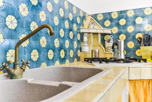 a kitchen with a sink and a blue and yellow wallpaper at Casa Vacanze Iosè in Rio Marina
