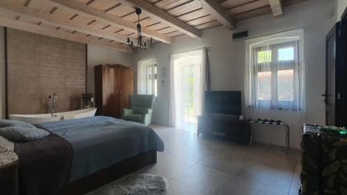 a bedroom with a bed and a tub and a sink at Mayday Cottage in Pócsmegyer