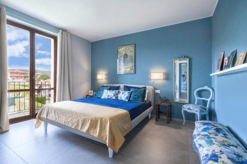 niebieska sypialnia z łóżkiem i balkonem w obiekcie Draisina Bike Apartments UNO w mieście Oleggio Castello