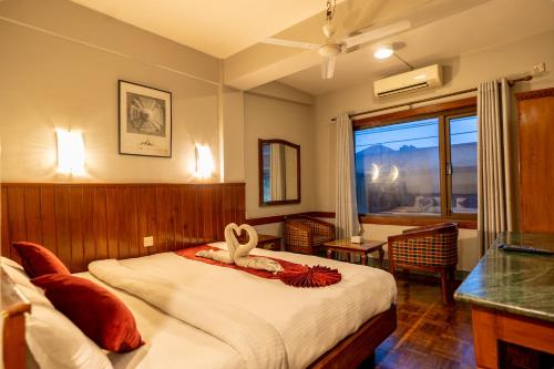 sypialnia z łóżkiem z dwoma łabędziami w obiekcie Mystic Homes Hotel w Katmandu