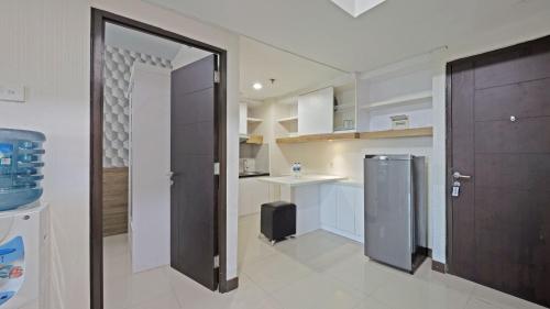 a kitchen with a door open to a kitchen with a refrigerator at Apartemen Grand Dhika City by Nina in Telukpucung
