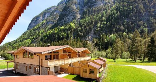 a large wooden house with a mountain in the background at Puitbach Chalet in Leutasch
