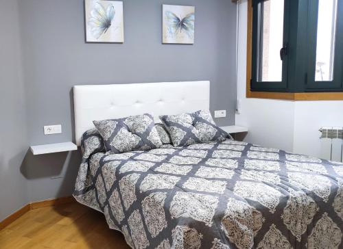 um quarto com uma cama e duas fotografias na parede em Os Reloxos II em Mondariz-Balneario