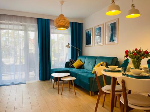 salon z zieloną kanapą i stołem w obiekcie Apartament Baltic A8 Pobierowo w Pobierowie
