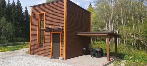 eine kleine Hütte mit einer Tür und einem Dach in der Unterkunft ŠMITI in (( Čūskumuiža ))
