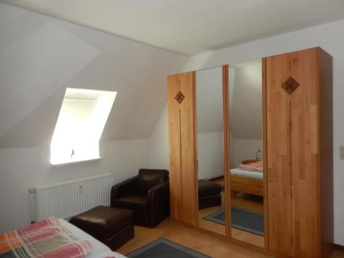 a bedroom with a mirror and a bed and a skylight at Landhaus Katharina in Westerdeichstrich