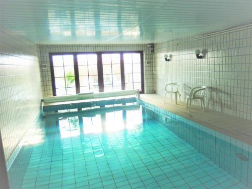 a large swimming pool with a table and chairs at Landhaus Katharina in Westerdeichstrich