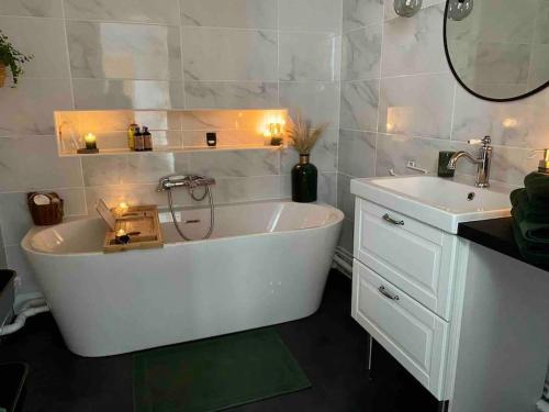 une salle de bain avec une baignoire blanche et un lavabo dans l'établissement Appartement VH III, au Mans