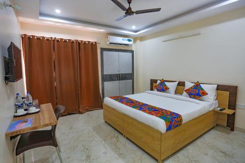um quarto com uma cama, uma mesa e uma televisão em FabHotel Starlight Sanctuary em Gurgaon